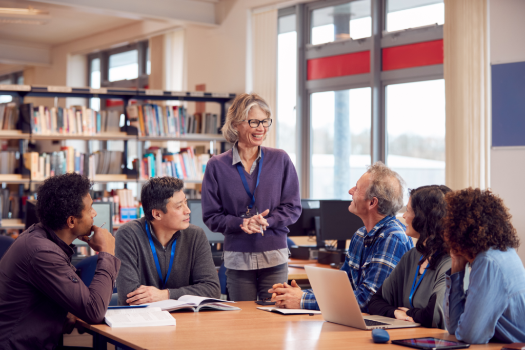 Teacher with group of mature adult students in class held at a library